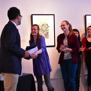 Students shaking hands with a professor